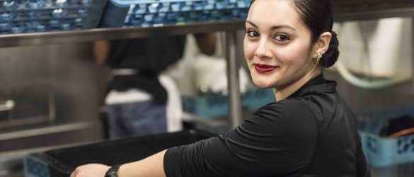 Smiling Young hispanic female kitchen worker looking at the camera